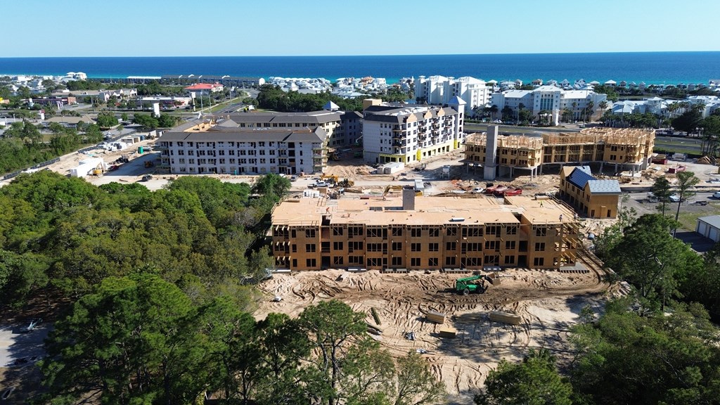 A construction site with a building under construction surrounded by trees.