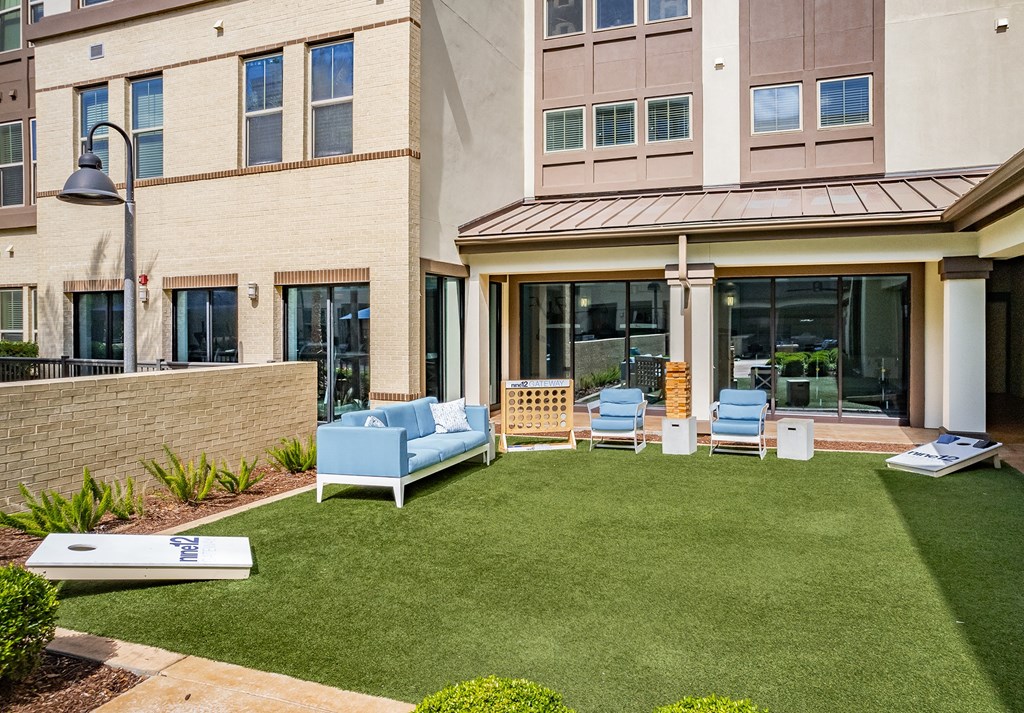 a yard with a couch and chairs in front of a building