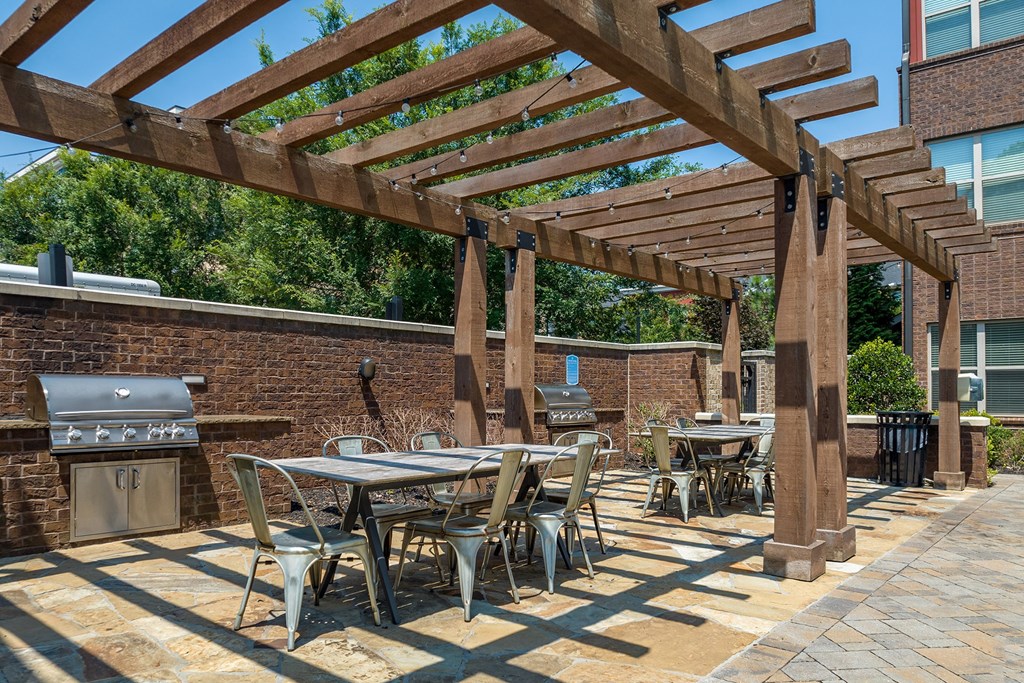 a patio with tables and chairs and a pergola