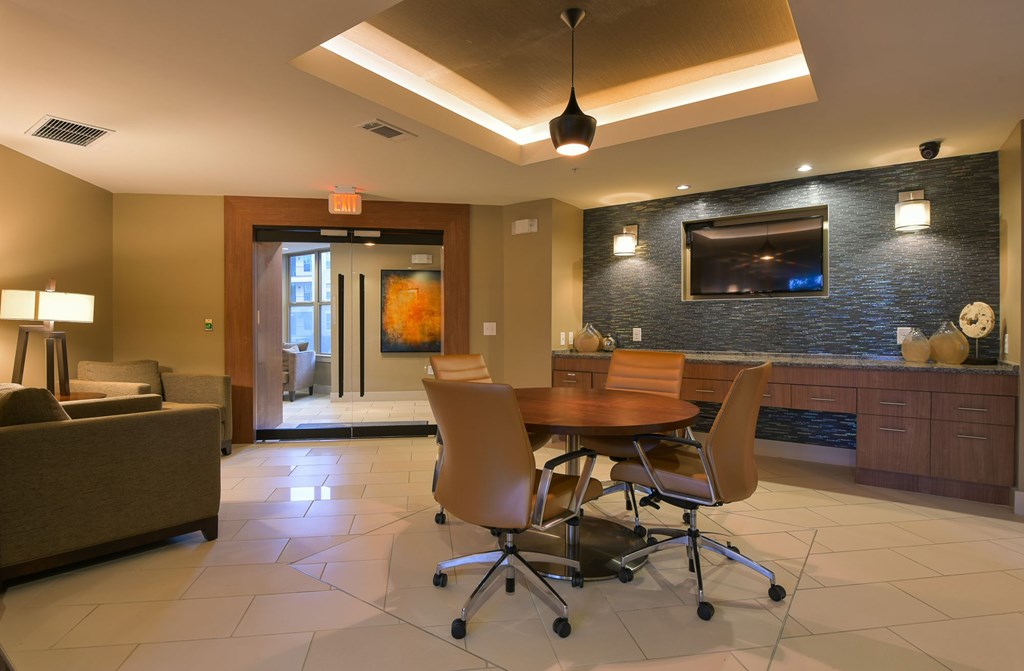A modern living room with a brown couch, a wooden table, and a television.