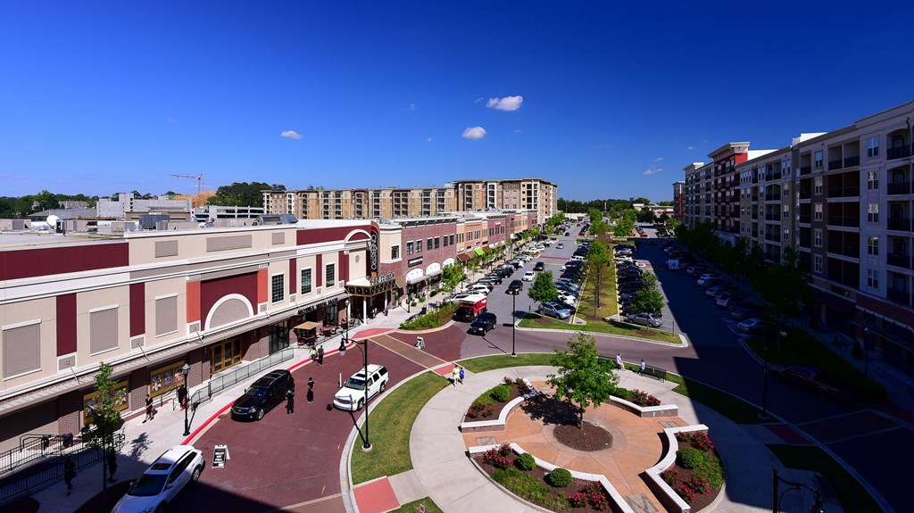 A city street with cars and buildings on either side.
