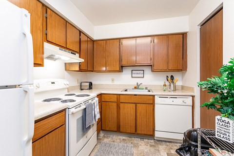 A kitchen with wooden cabinets and white appliances.
