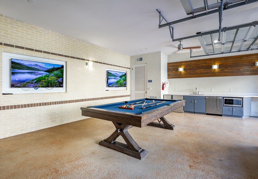 a games room with a pool table and a painting on the wall