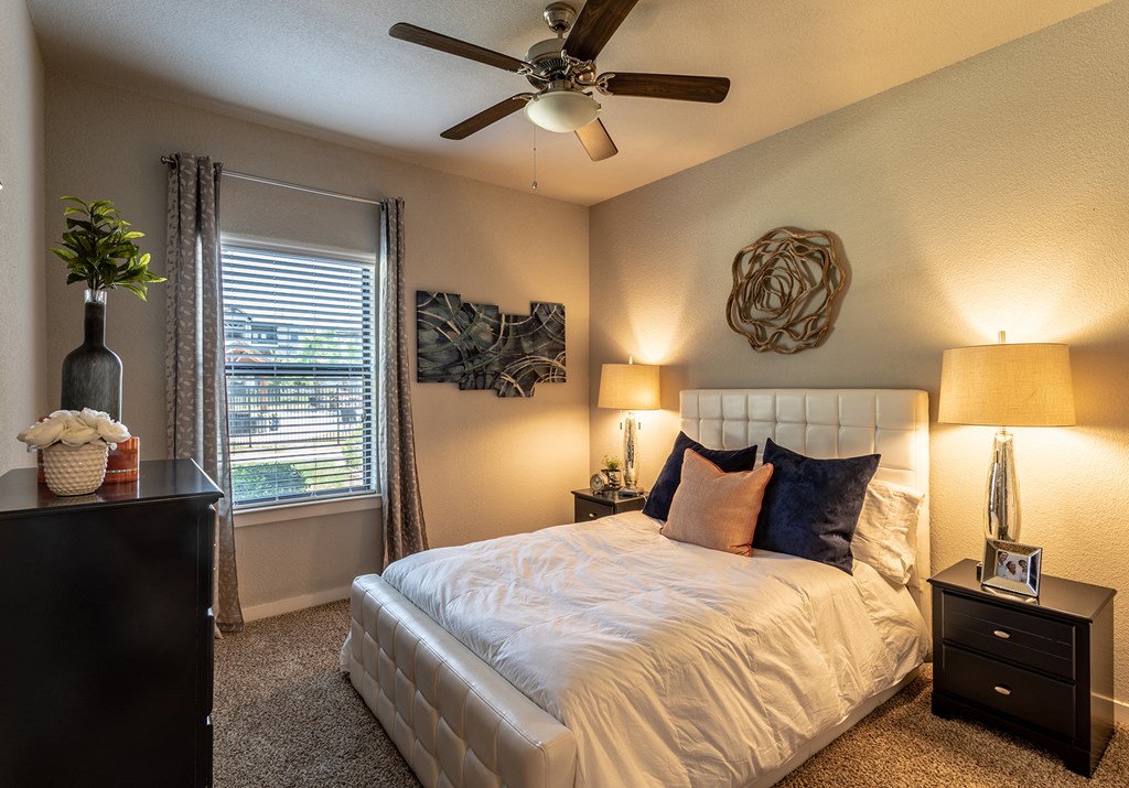 a bedroom with a large bed and a ceiling fan