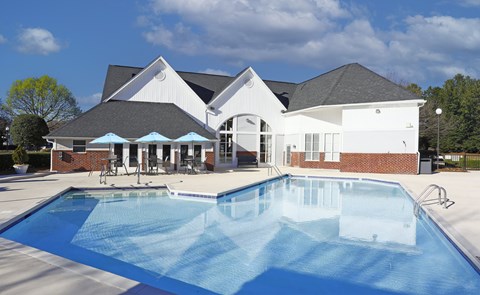 Charlotte, NC, Apartments Near ALDI - Coffey Creek - A Bright Outdoor Swimming Pool With Brick Accents, Patio Seating, Blue Umbrellas.