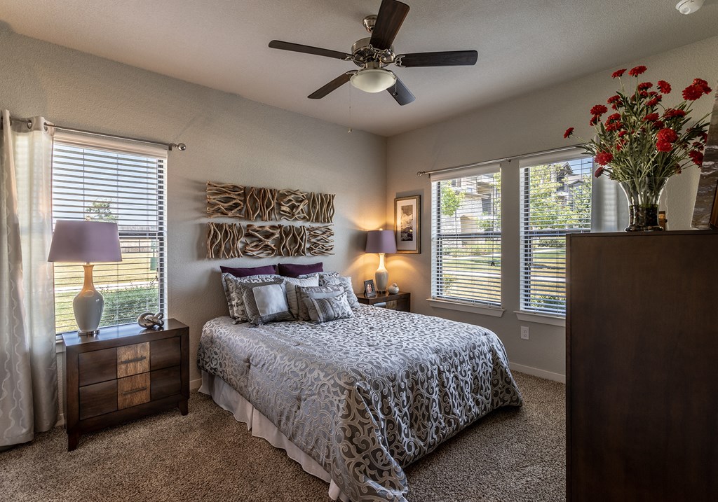 a bedroom with a large bed and a ceiling fan