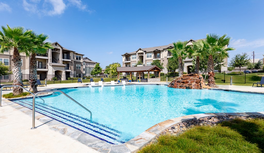 a large swimming pool with an apartment building in the background