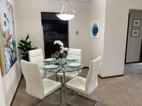 a dining room with a glass table and white chairs