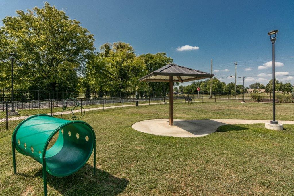 a playground with a swing set and a picnic shelter