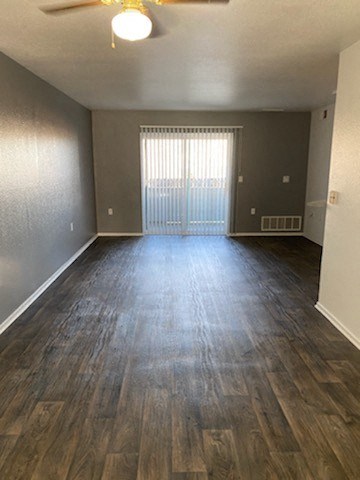 an empty room with a window and a ceiling fan