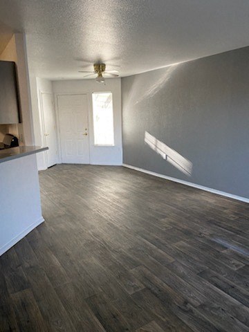 an empty living room with a ceiling fan