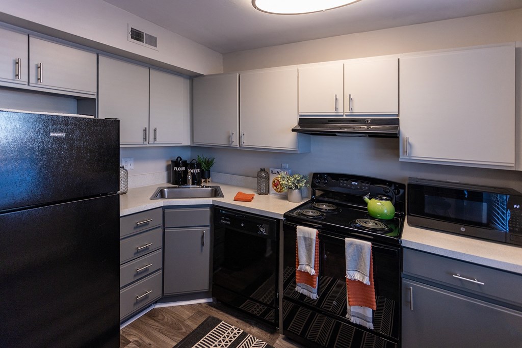 a kitchen with white cabinets and black appliances