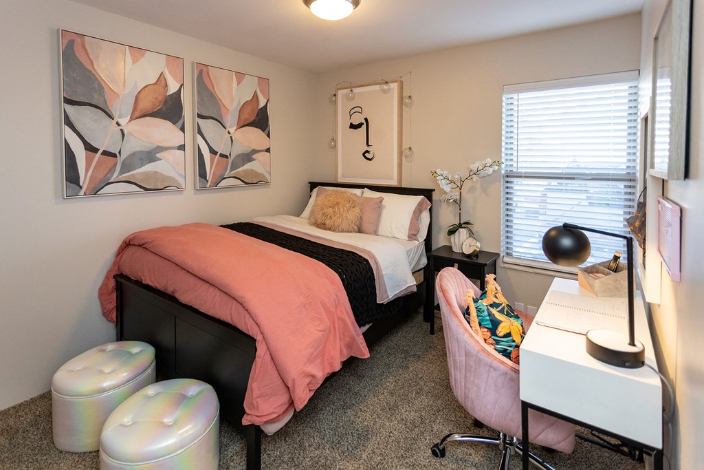 a bedroom with a bed and two paintings on the wall
