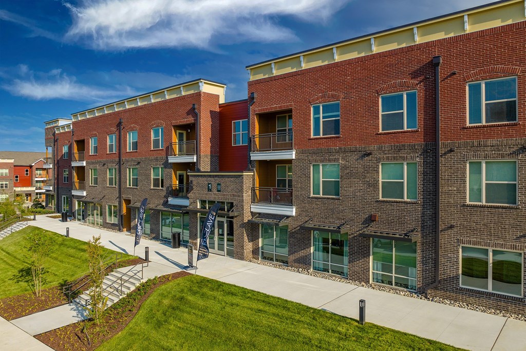 a view of a building with a sidewalk and grass