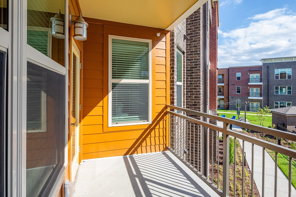 the view from the balcony of a home with a yellow wall and a balcony railing