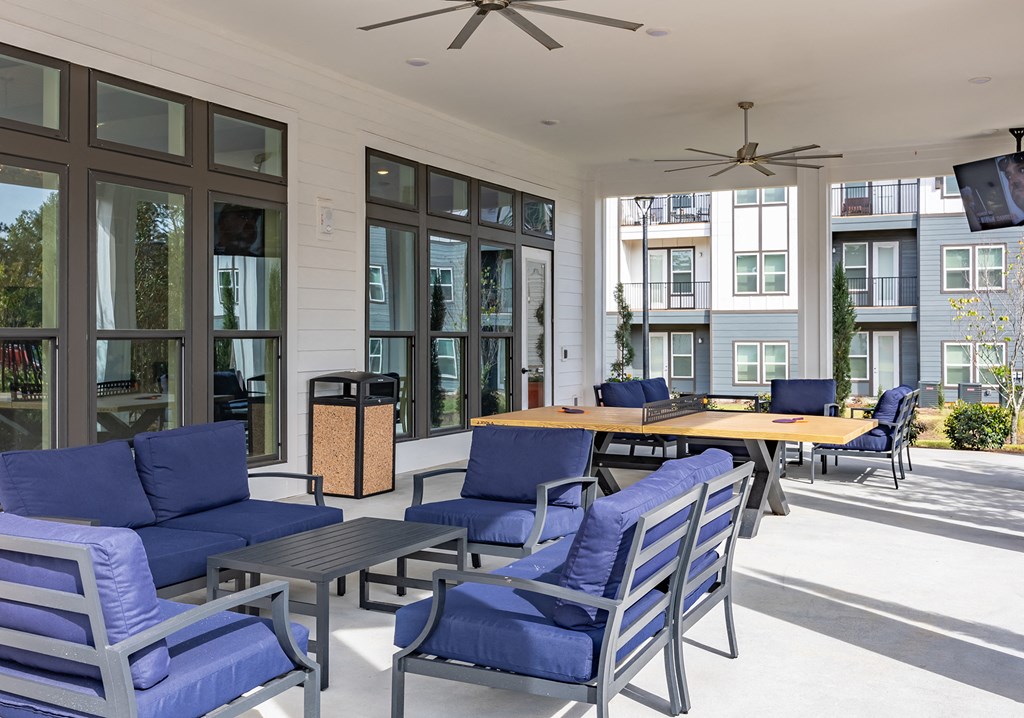 One-BR Apartments In Antioch, TN - Novo Hickory Highlands - Outdoor Resident Lounge With Tables, Couches, TV, And Ping Pong Table