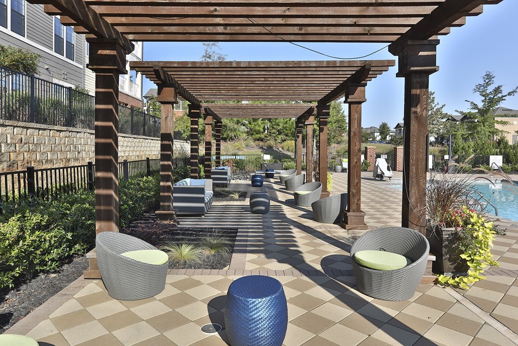 a covered patio with wicker seating and a pool