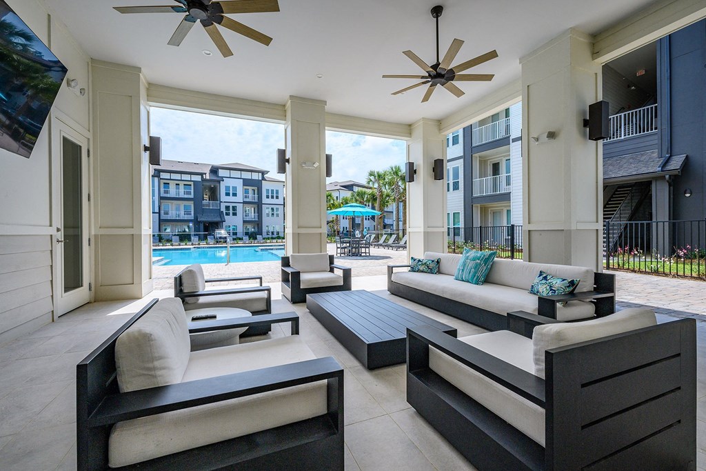 a living room with furniture and a pool in the background