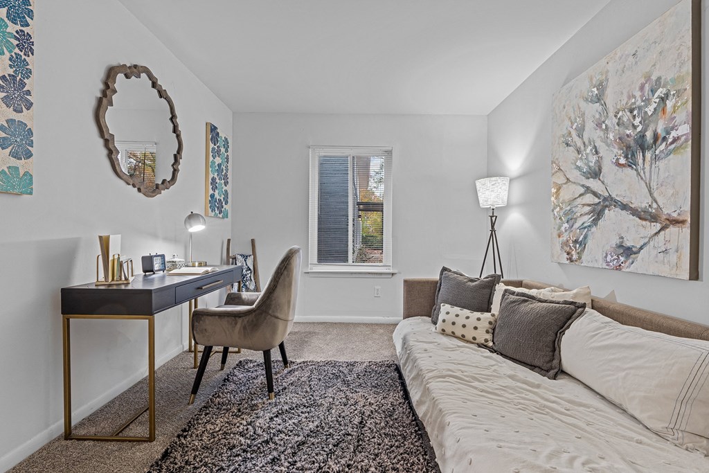 a living room with a couch and a desk with a mirror