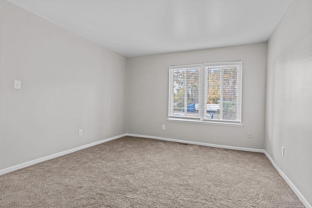 an empty room with carpet and a window