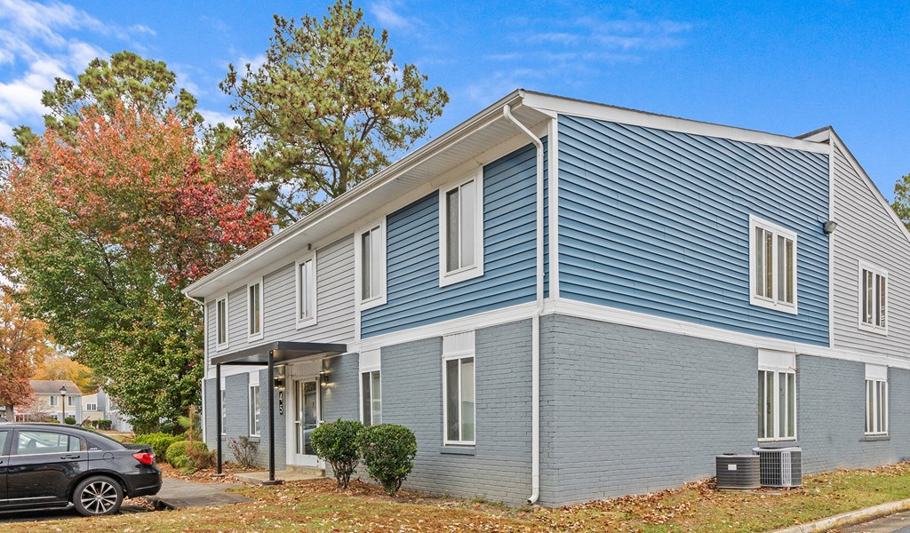 a blue house with a car parked in front of it