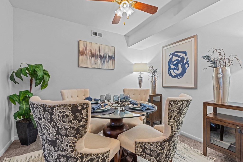 a dining room with a table and chairs and a ceiling fan