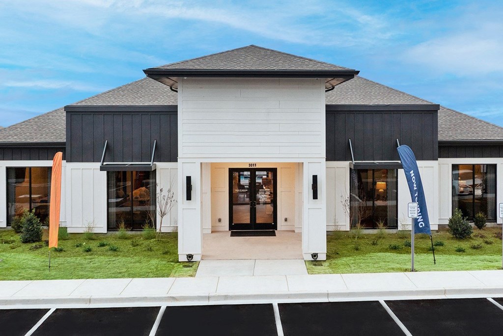 the front of a white building with a blue flag