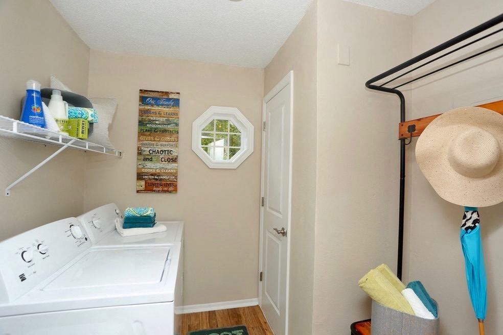 a laundry room with a washing machine and a hat on the wall