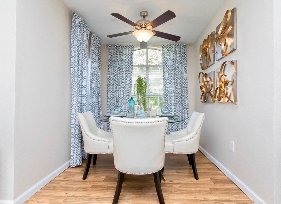 a dining room with a ceiling fan and a window