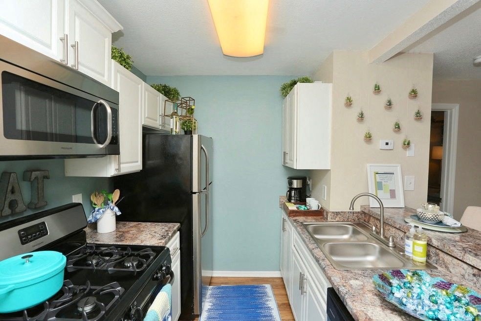 a kitchen with a stove and a refrigerator and a sink