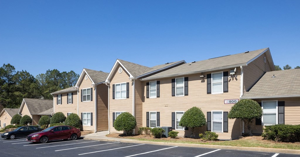 a row of houses with cars parked in a parking lot