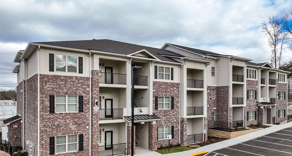 the outlook of an apartment building with balconies and a parking lot