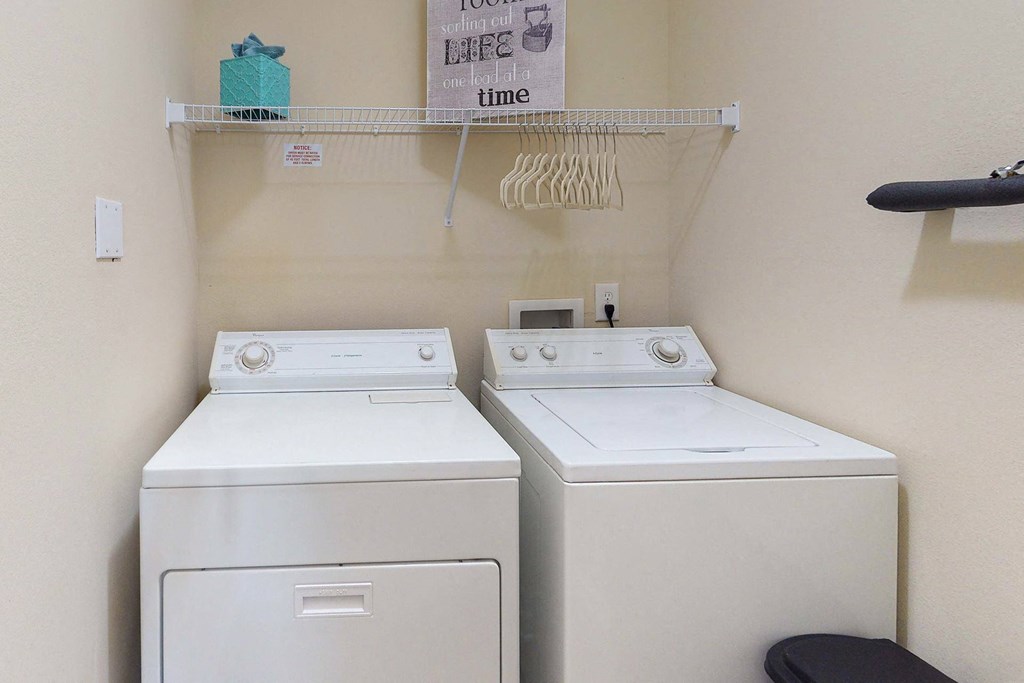 two washers and a dryer in a laundry room