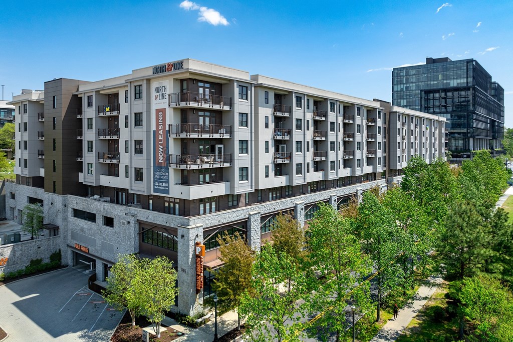 A large apartment complex with a parking lot in front.