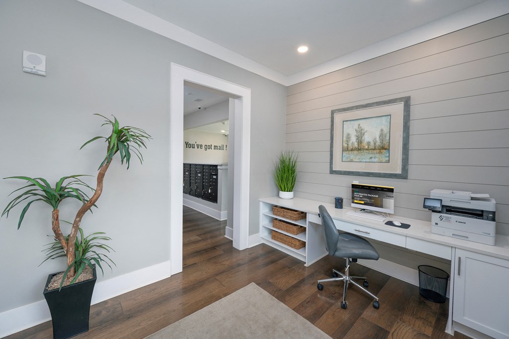 a home office with a desk and a plant