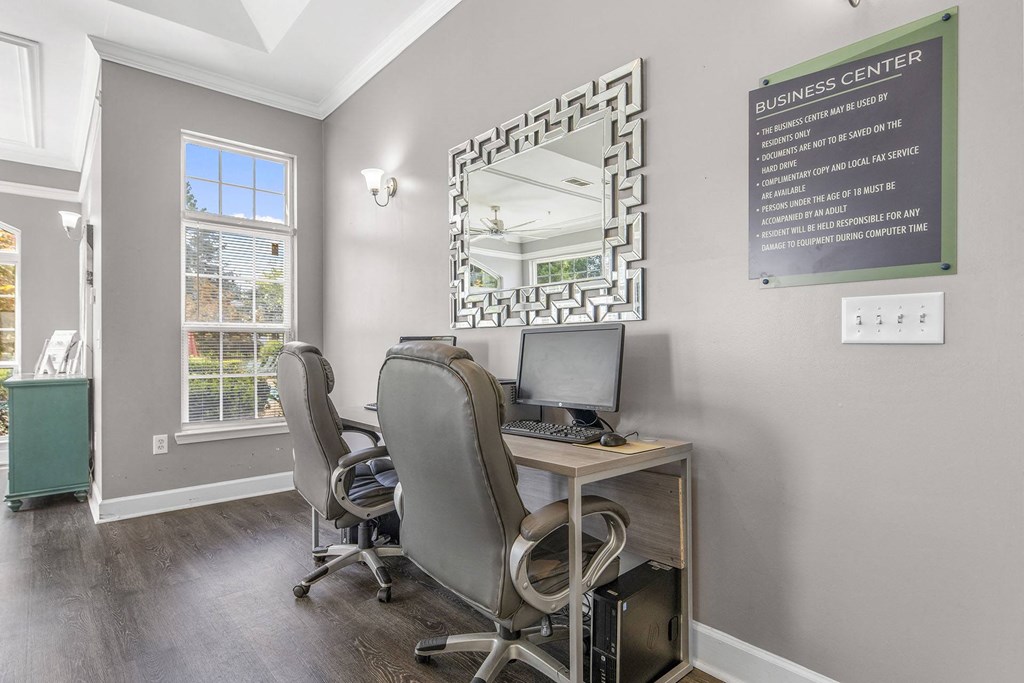 A business center with a sign on the wall and a mirror on the desk.