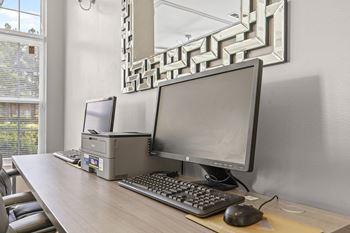 A desk with a computer, keyboard, and mouse.