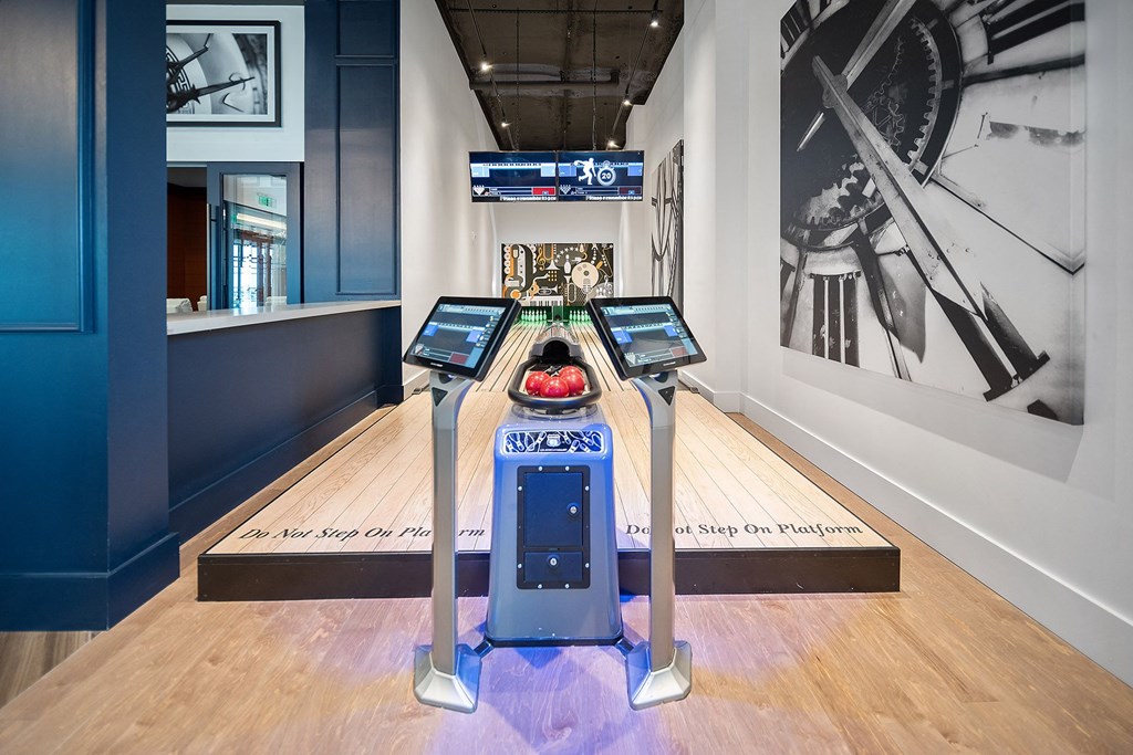 a bowling alley with two lanes of bowling pins and a bowling ball on one of the lanes at Altis Grand Central, Tampa Florida