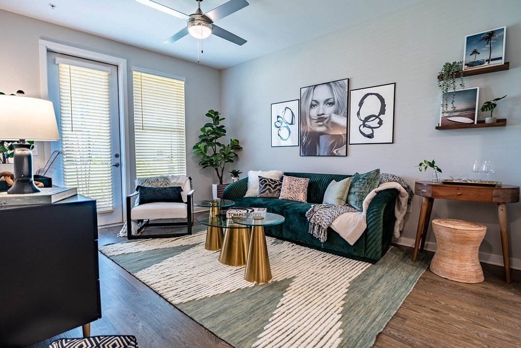 Apartments Near Clemson University - The Aster - Living Room with Couch, Coffee Table, Chair, Area Rug, and Large Window