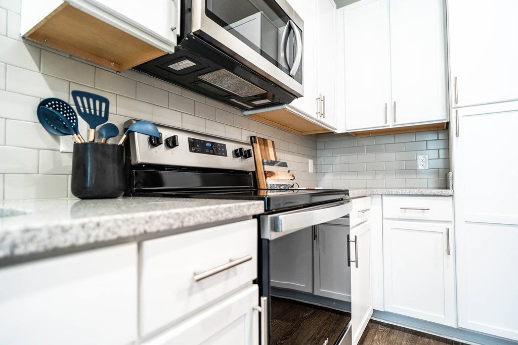 a kitchen with white cabinets and stainless steel appliances
