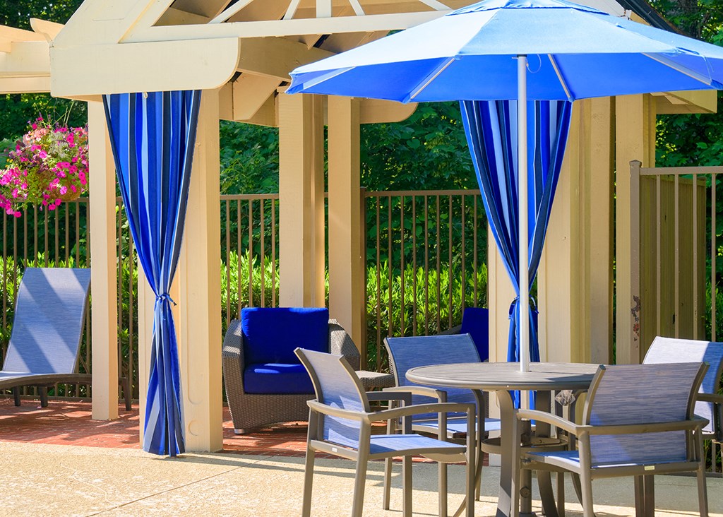 a patio with blue chairs and tables with umbrellas