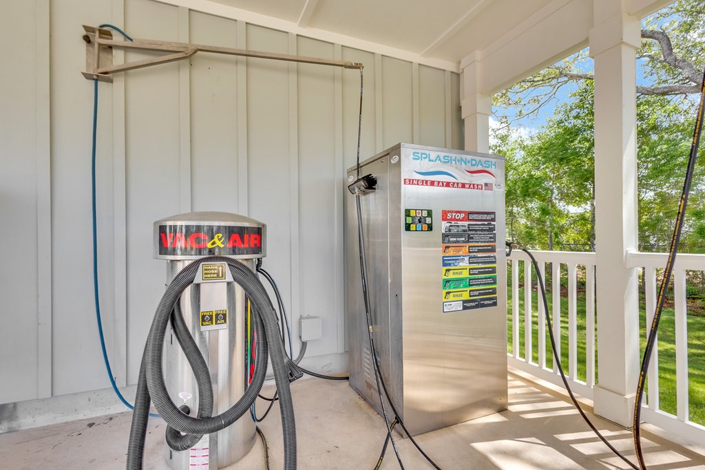 A gas pump and a Splashdown refrigerator are on a porch.