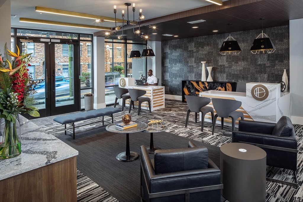 the lobby or reception area of a hotel with a reception desk and chairs