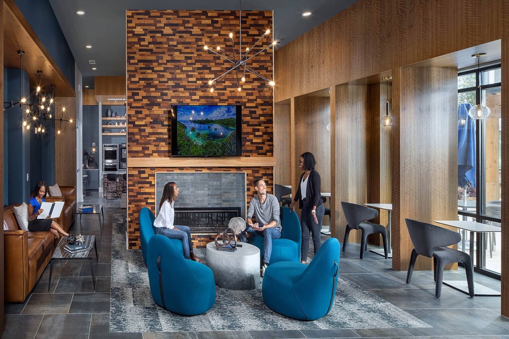 a group of people sitting in a lobby with a fireplace