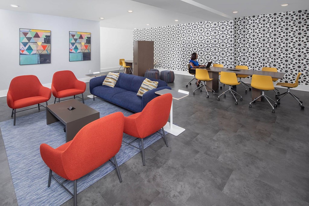 a room with a couch and chairs and a person sitting at a table