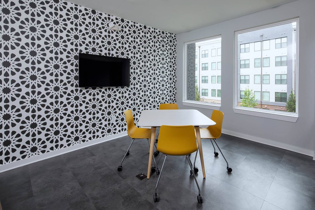 a room with a table and chairs and a television