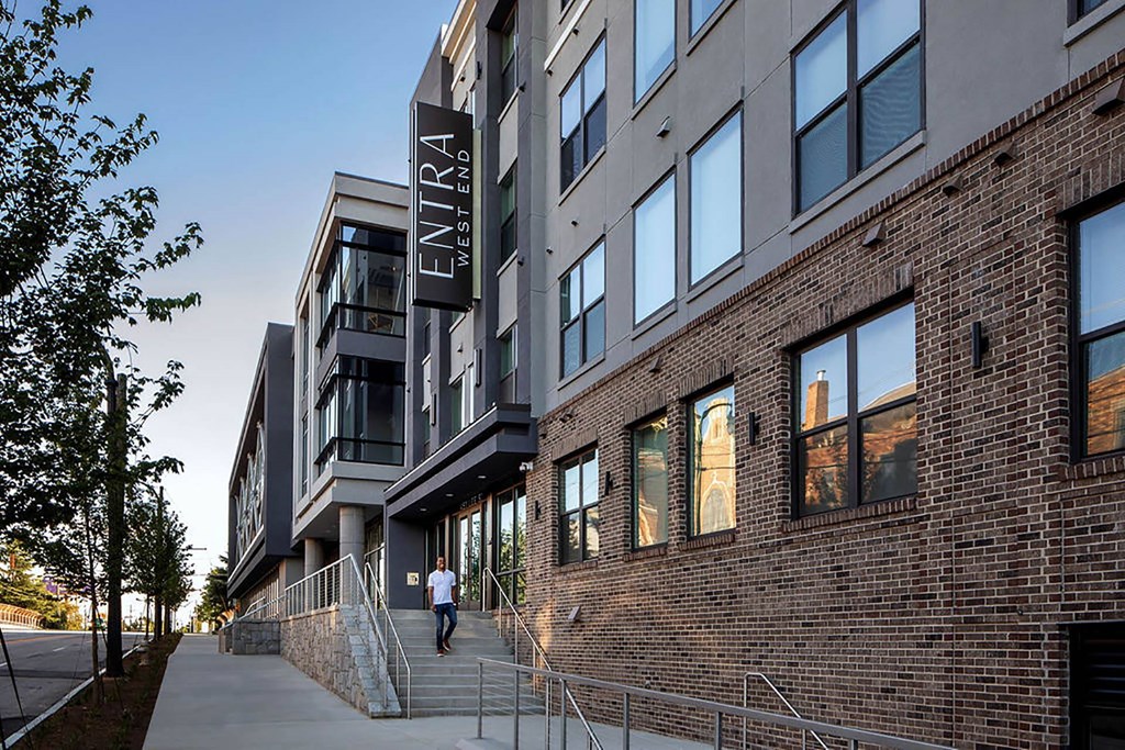 a person walking down the sidewalk in front of a building