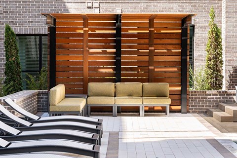 A wooden slat fence with a bench in front of it.