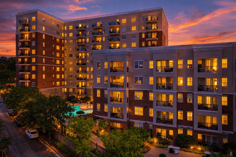A large apartment complex with a pool in the courtyard.