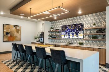a bar with a white counter and chairs and a tv on the wall